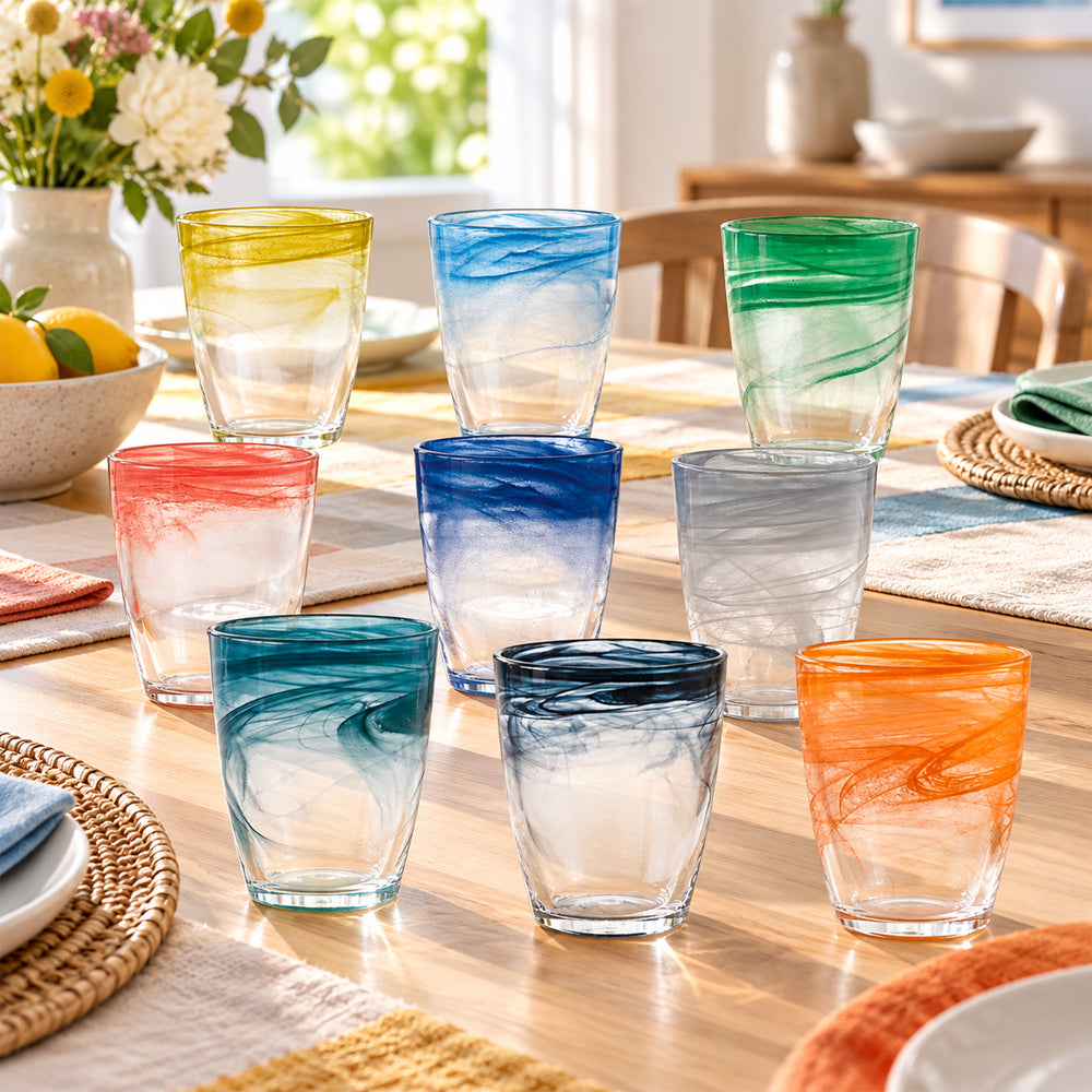 Verloop waterglazen in diverse kleuren op gedekte tafel zachte warme uitnodigende sfeer
