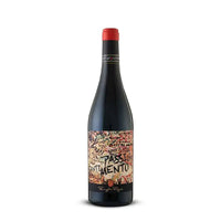 Bottiglia di vino rosso con etichetta decorativa colorata e scritte in nero, tappo rosso, su sfondo neutro.