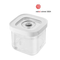 Contenitore quadrato trasparente con coperchio bianco e tappo centrale, design moderno, premio Red Dot 2024 visibile.