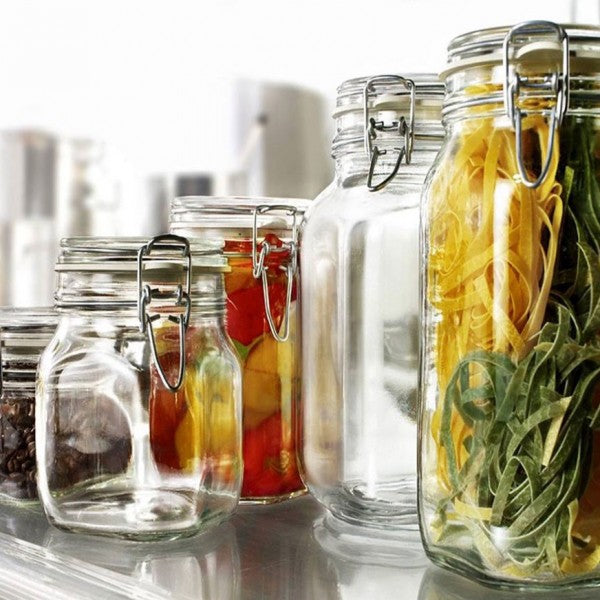 barattoli in vetro con chiusura ermetica contenenti pasta gialla e verde, pomodori e altri alimenti su
