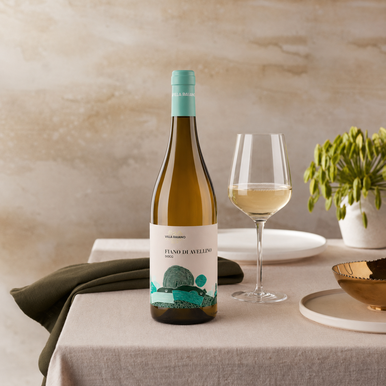 Bottiglia di vino bianco Fiano di Avellino su un tavolo con tovaglia chiara, bicchiere con vino e piatti decorativi.